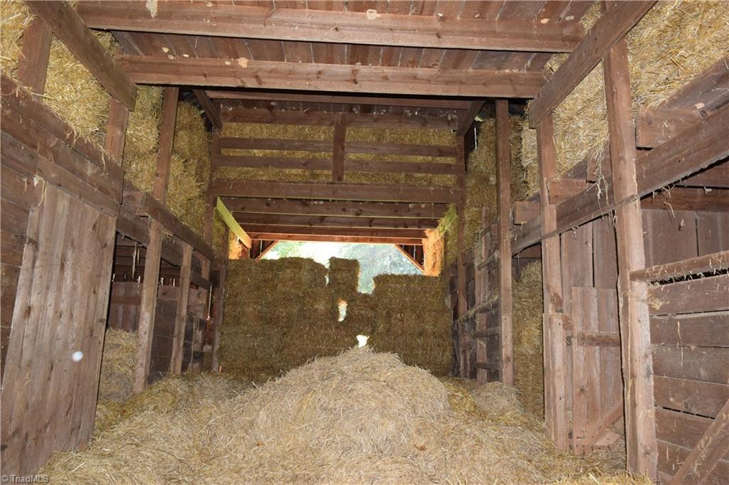 1030 Ellisboro Road Madison, NC 27025 - Photo 14 of 30 Interior of the animal barn, currently being used to store hay. Multiple stalls and 2nd level. Barn is in great shape for its age.