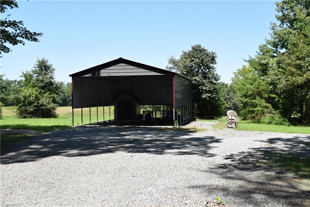 1030 Ellisboro Road Madison, NC 27025 - Photo 17 of 30 Huge RV or large equipment carport with wide gravel driveway leading in.