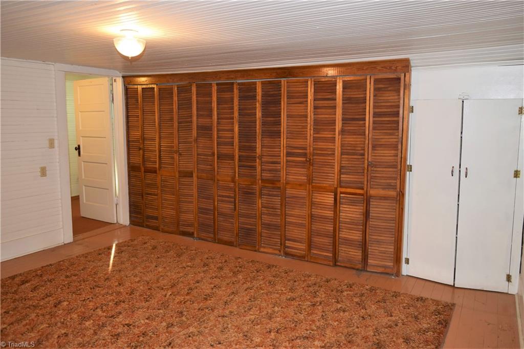 1030 Ellisboro Road Madison, NC 27025 - Photo 27 of 30 3rd Bedroom: Wood floors with tons of cabinet space. Upstairs is cooled by window units and heated with propane gas heaters (vented out of house and afixed)