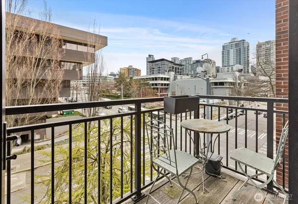 a view of a city from a balcony with chairs