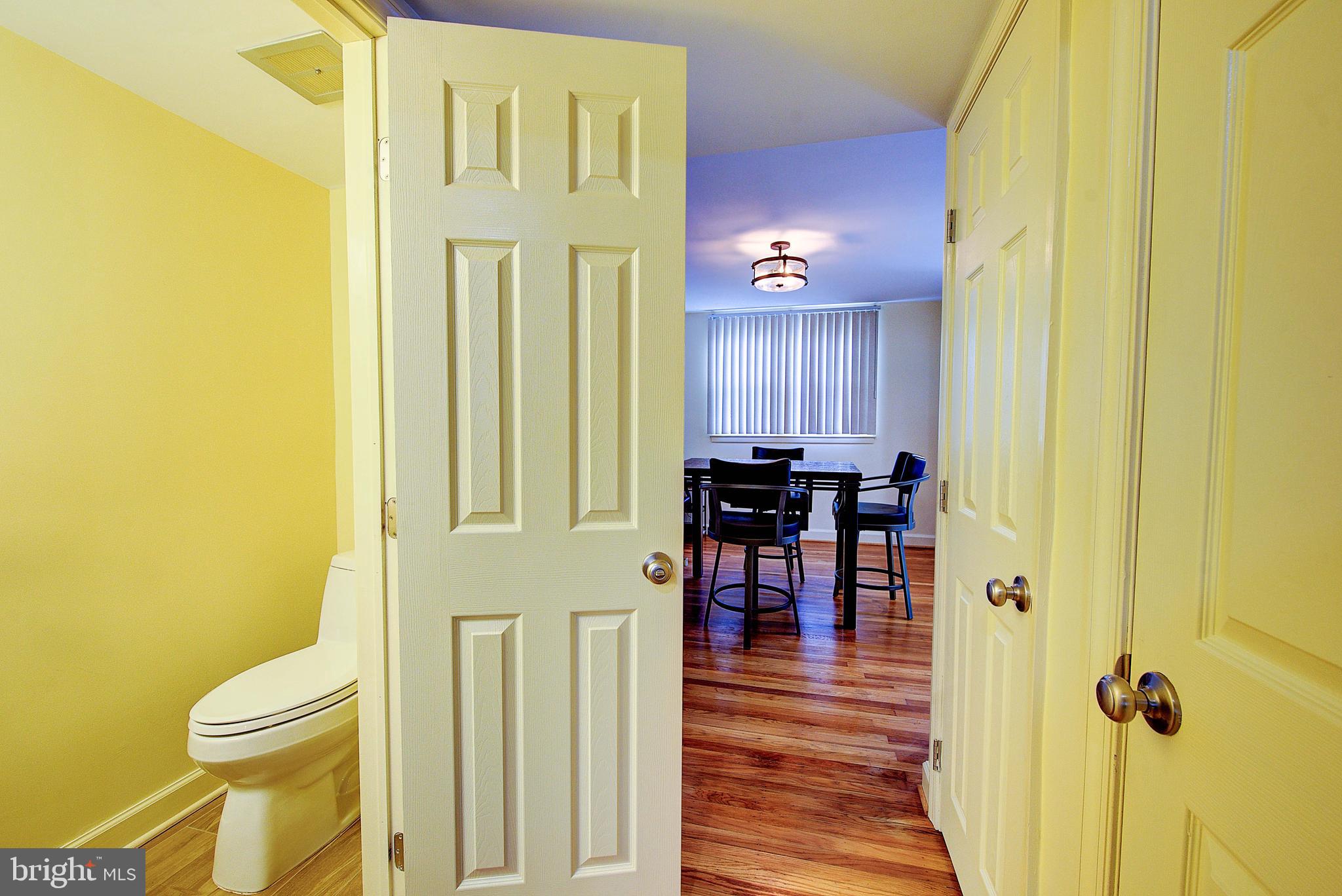1367 Adair Road Brookhaven, PA 19015 - Photo 9 of 34 a view of a hallway with wooden floor and a bathroom
