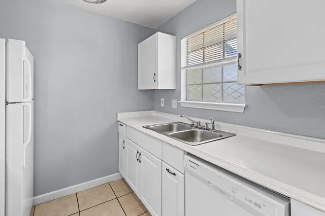 a kitchen with appliances cabinets a sink and a window