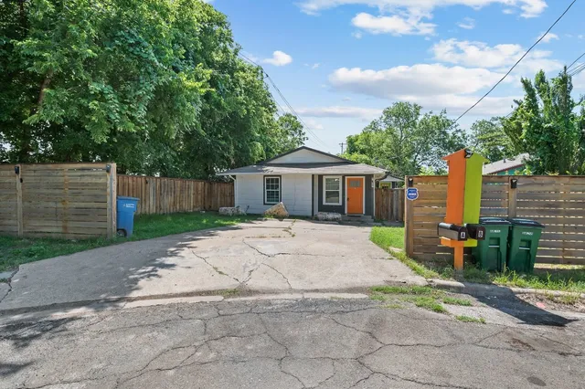 a front view of a house with a garden and trees