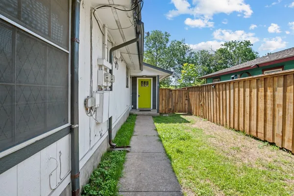 a view of a pathway of house with wooden fence