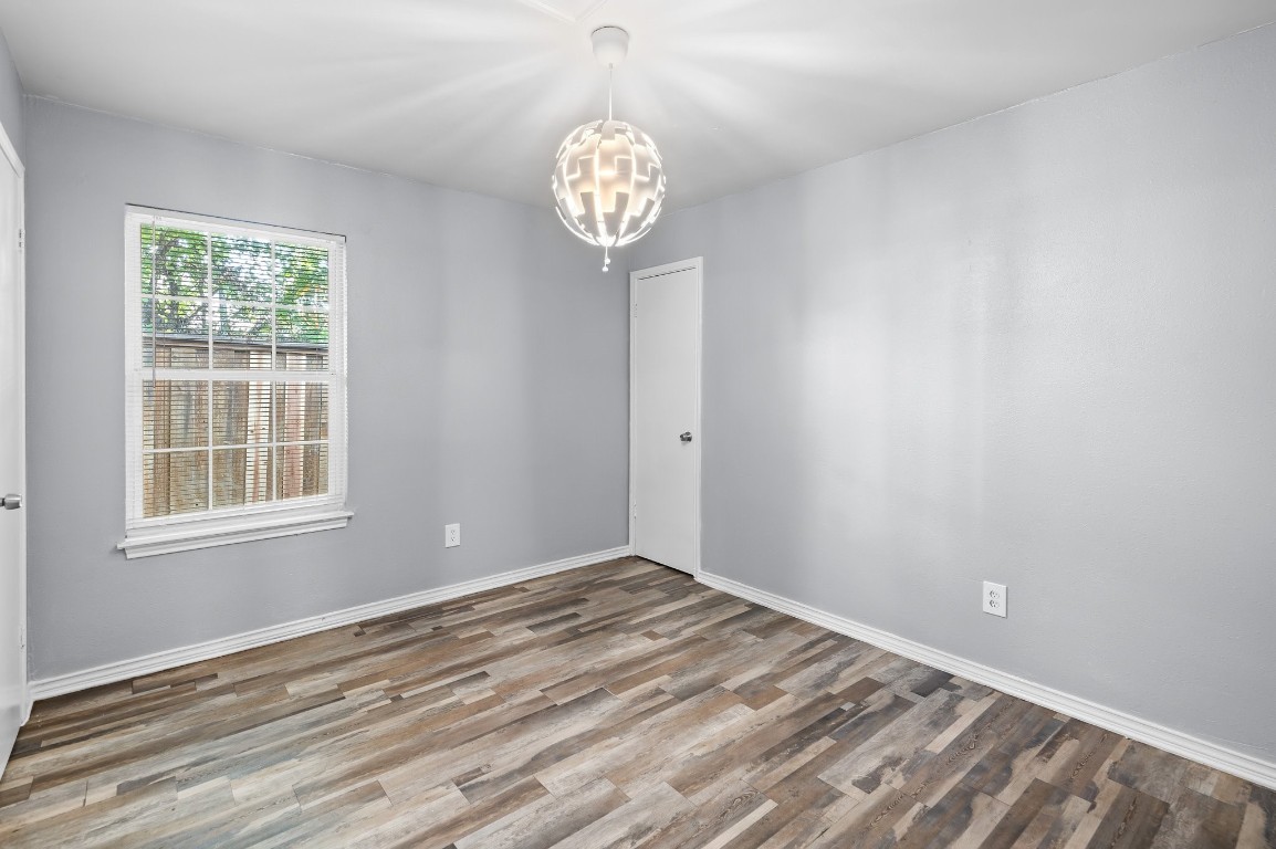 7617 Meador Avenue, Unit A Austin, TX 78752 - Photo 9 of 21 an empty room with wooden floor and a window