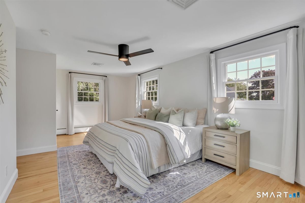 361 Miles Road Orange, CT 06477 - Photo 12 of 40 Two bedrooms on the second level, including the master bedroom with hardwood flooring, ceiling fan, and a walk-in closet with custom built-ins.
