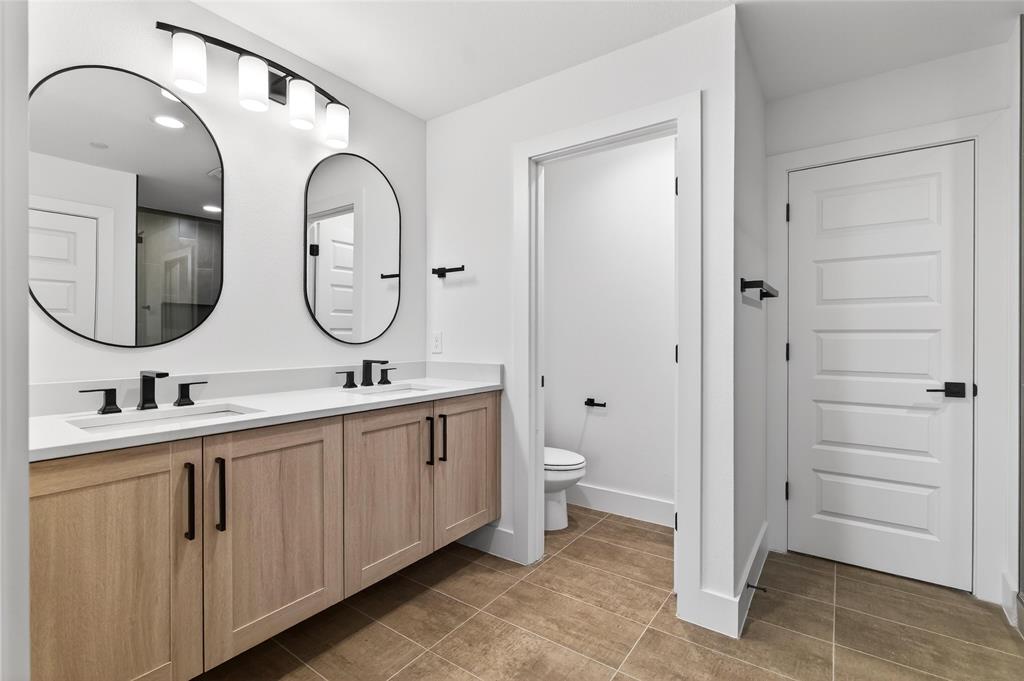 8901 Lowell Street Rowlett, TX 75089 - Photo 18 of 24 Bathroom with double vanity and dark tile patterned flooring