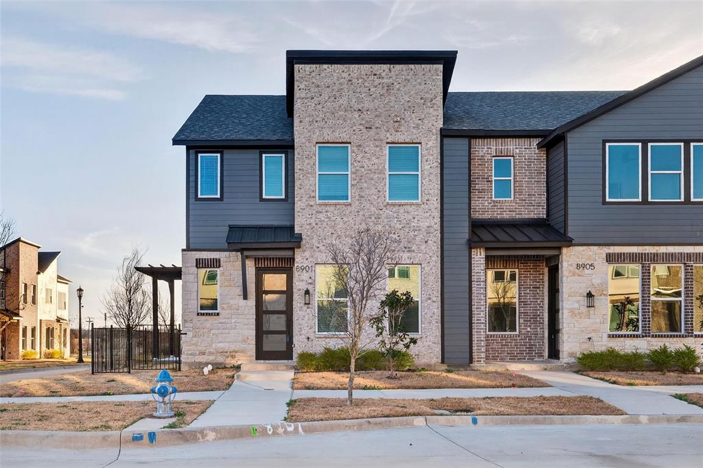 8901 Lowell Street Rowlett, TX 75089 - Photo 3 of 24 Contemporary house featuring stone siding, a standing seam roof, roof with shingles, and brick siding