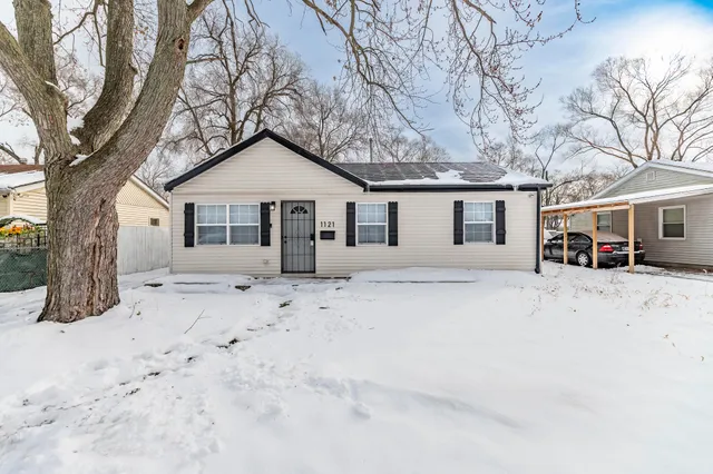 a front view of a house with a yard covered in snow