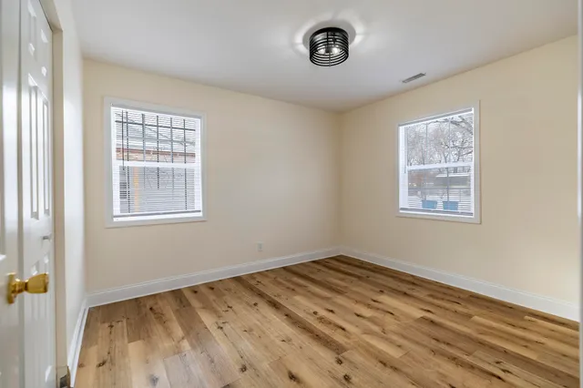 a view of a room with wooden floor and windows
