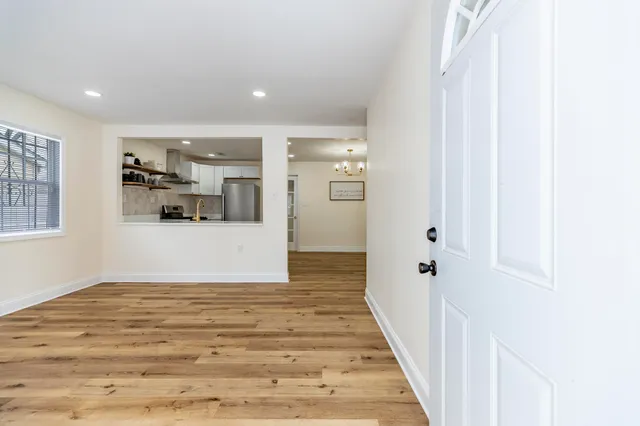 a view of a hallway with wooden floor and windows