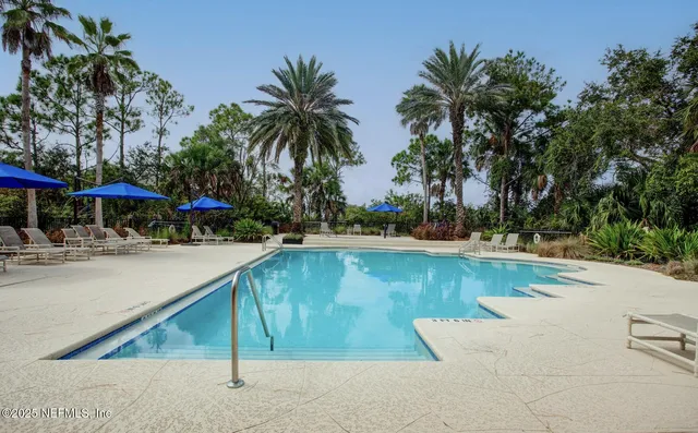 a view of a swimming pool with a patio and a yard