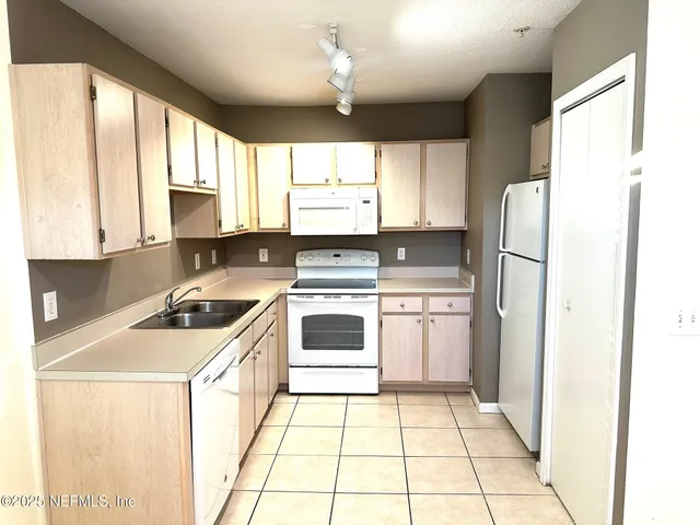 a kitchen with a stove a sink and a refrigerator