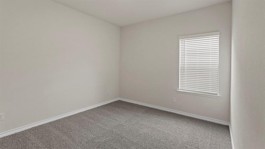 447 Epiphany Lane Lavon, TX 75166 - Photo 22 of 31 Neutral-toned room featuring a single window with blinds, light gray walls, and gray carpeting