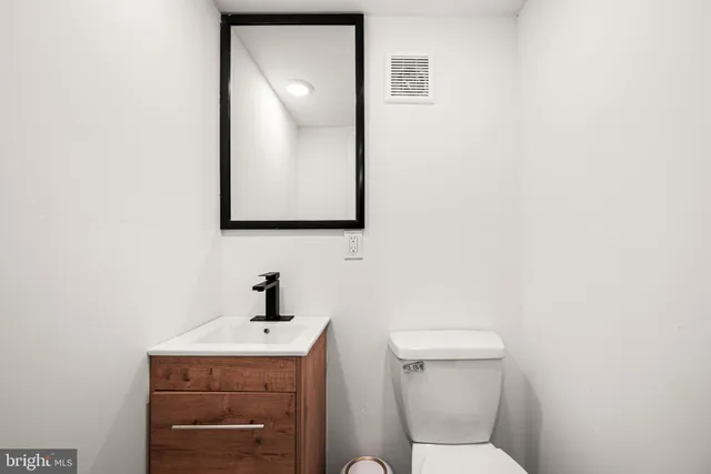 a bathroom with a toilet a sink and mirror