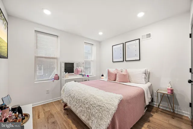 a bedroom with a bed and wooden floor