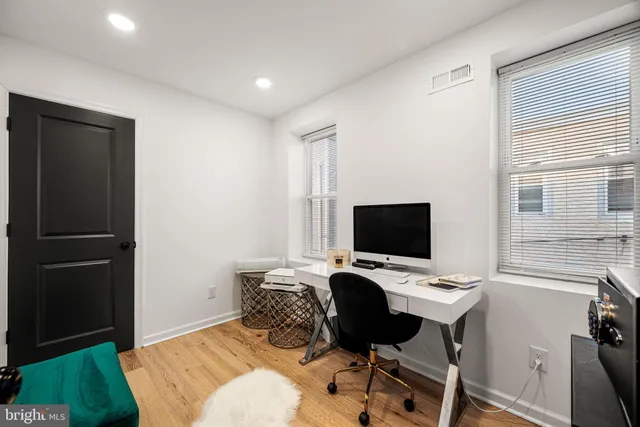 a view of a workspace with furniture and a window
