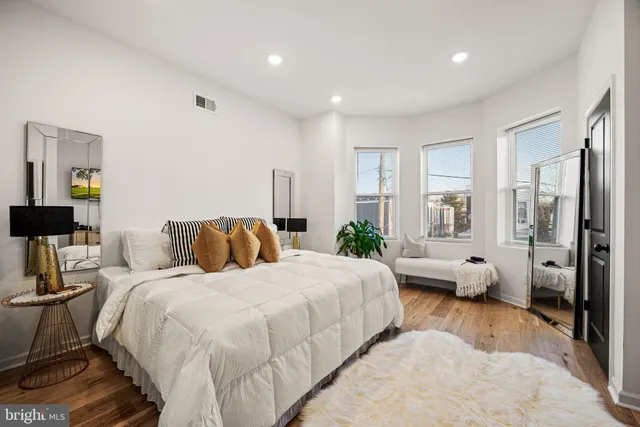 a spacious bedroom with a bed and glass door
