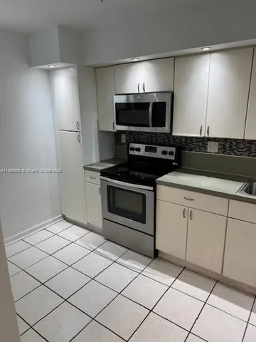 a kitchen with granite countertop a sink and a stove top oven