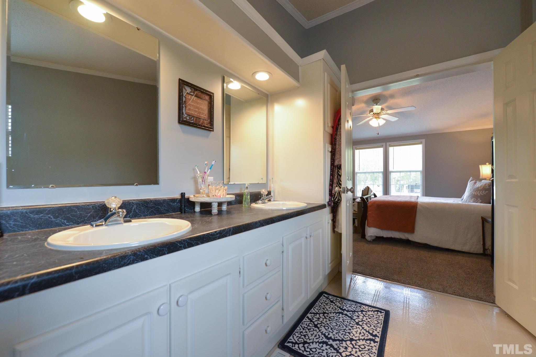 7175 Driver Road Zebulon, NC 27597 - Photo 14 of 30 a spacious bathroom with a double vanity sink and a mirror