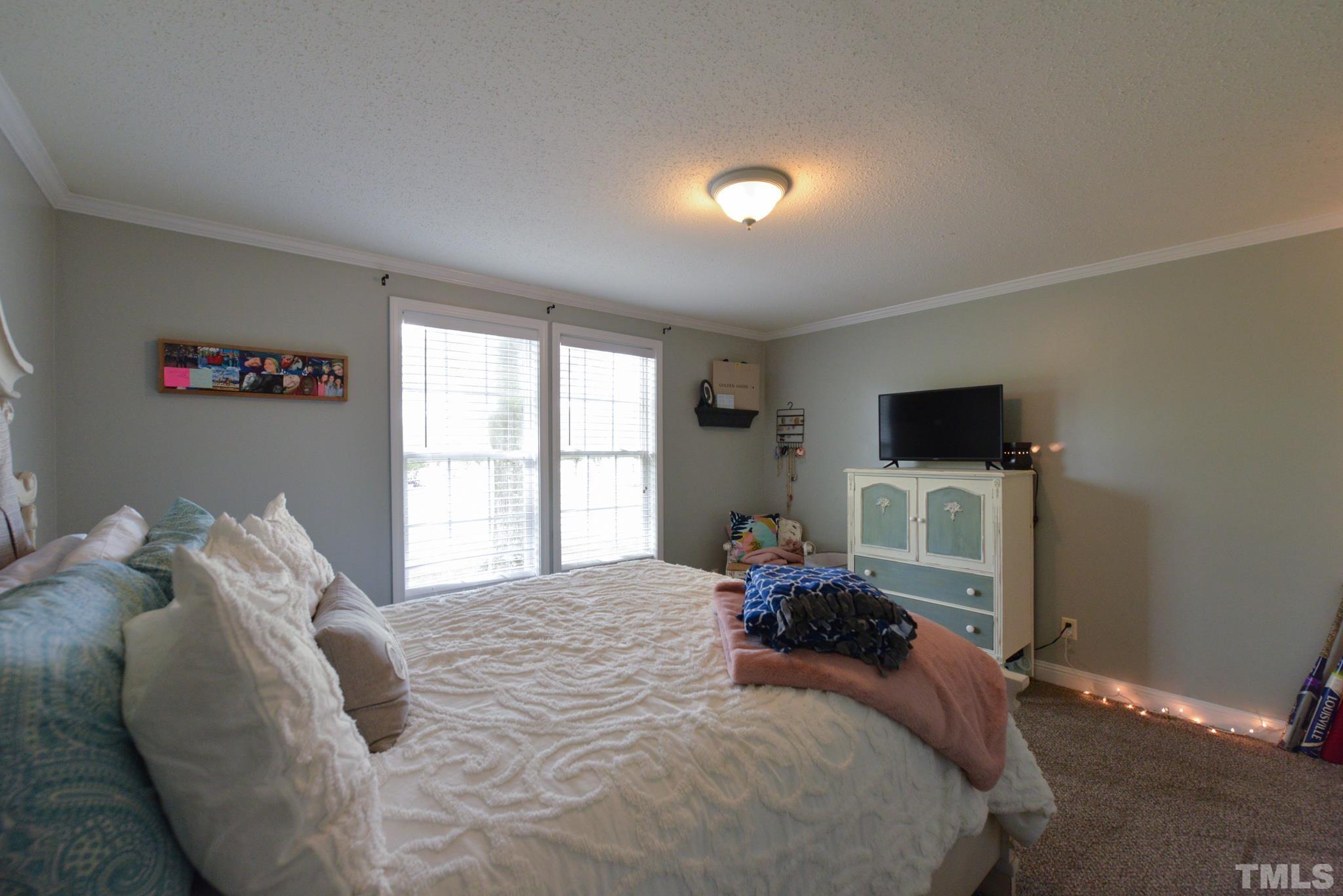7175 Driver Road Zebulon, NC 27597 - Photo 17 of 30 a bedroom with a bed and wooden floor