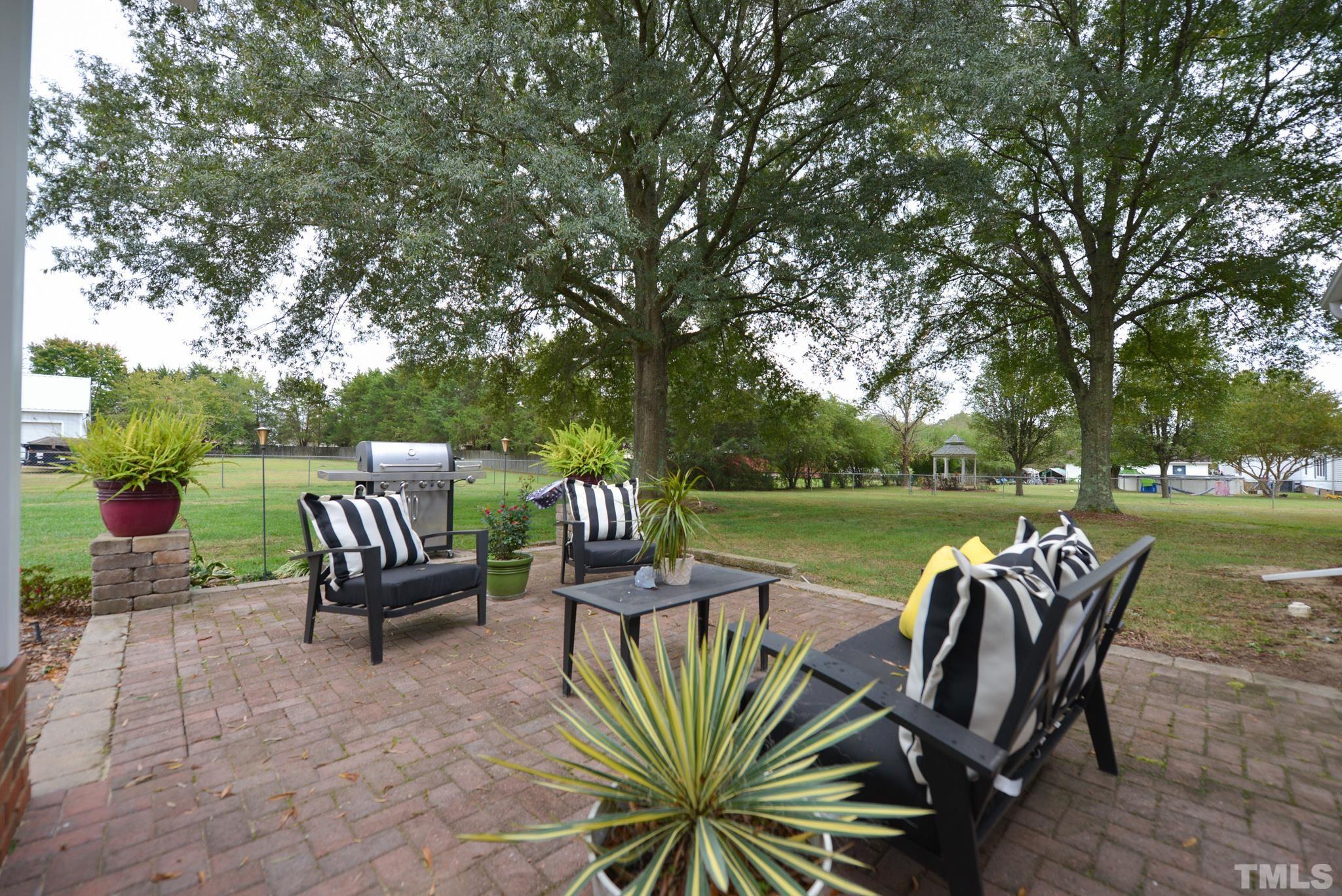 7175 Driver Road Zebulon, NC 27597 - Photo 25 of 30 a view of a patio with table and chairs potted plants and a large tree