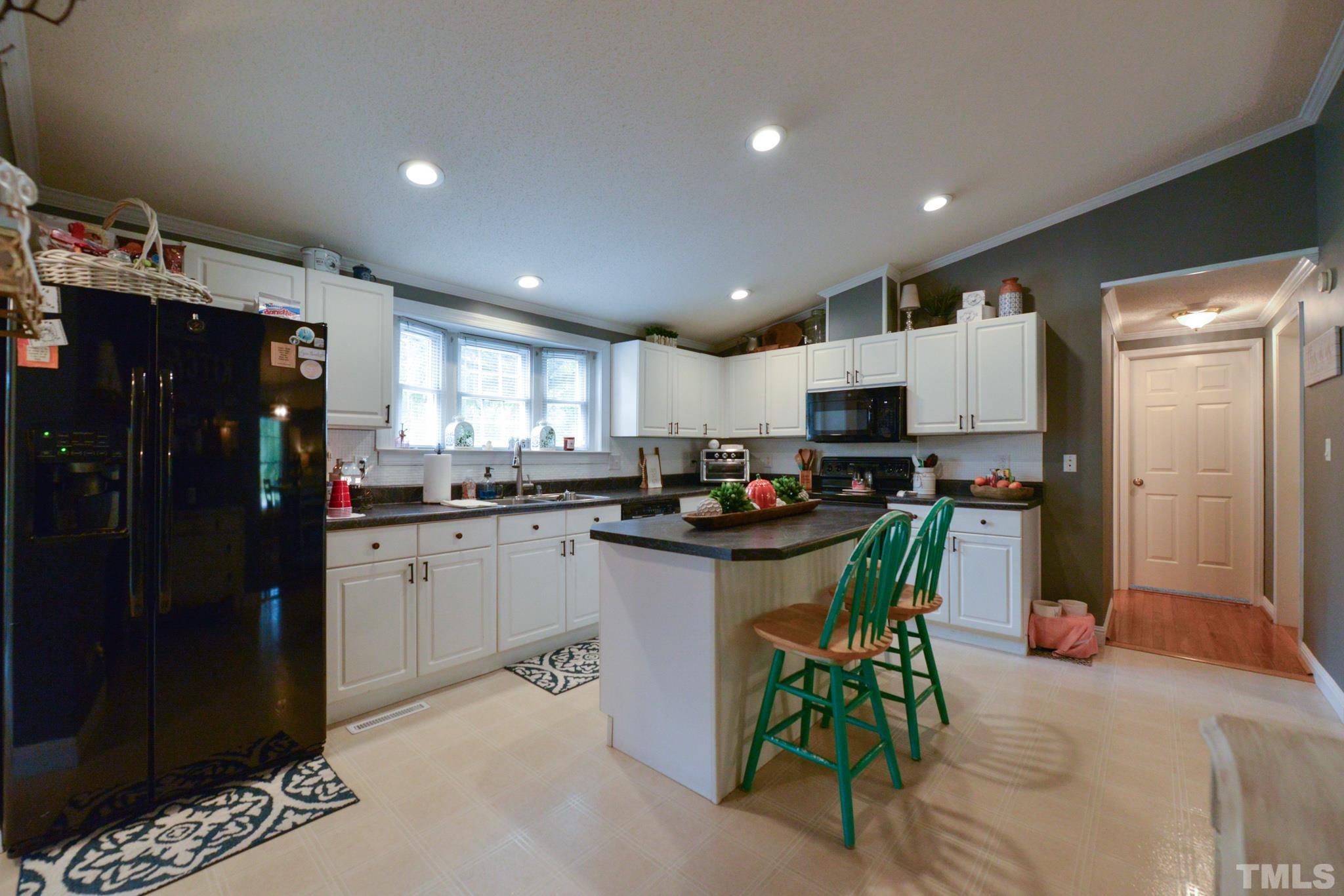 7175 Driver Road Zebulon, NC 27597 - Photo 9 of 30 a kitchen with refrigerator and chairs