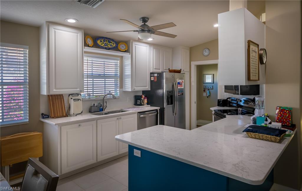 4167 St George Lane Naples, FL 34119 - Photo 2 of 14 a kitchen with refrigerator and window