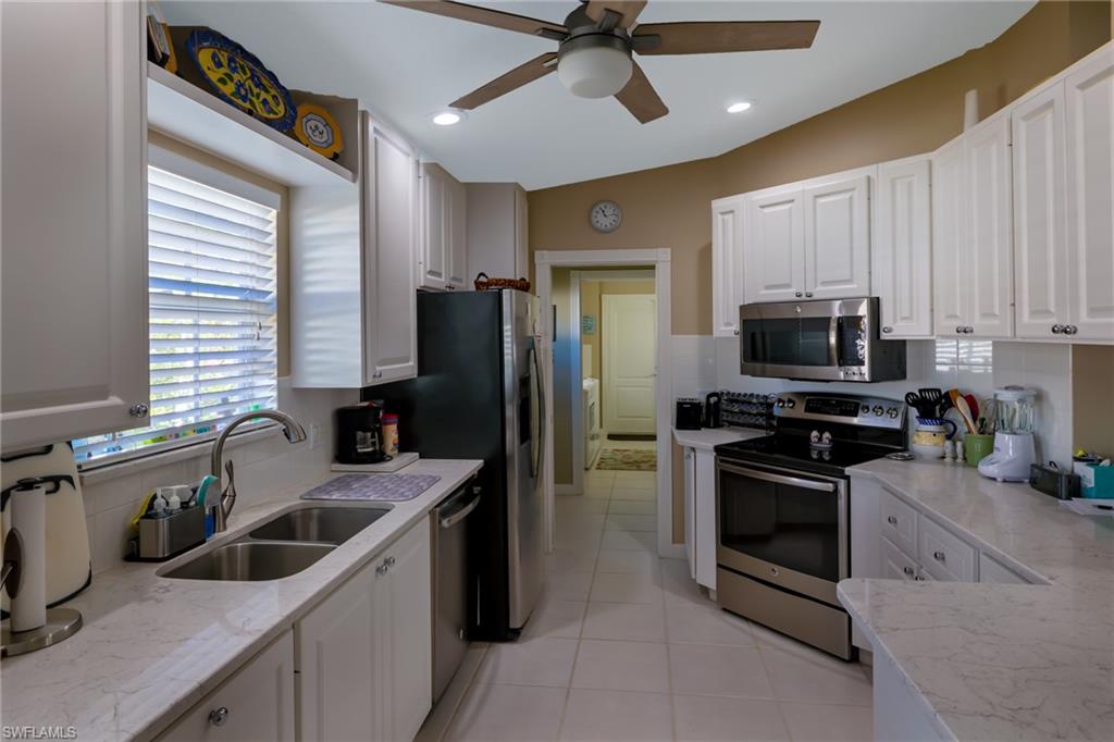 4167 St George Lane Naples, FL 34119 - Photo 3 of 14 a kitchen that has a sink cabinets stainless steel appliances and a window