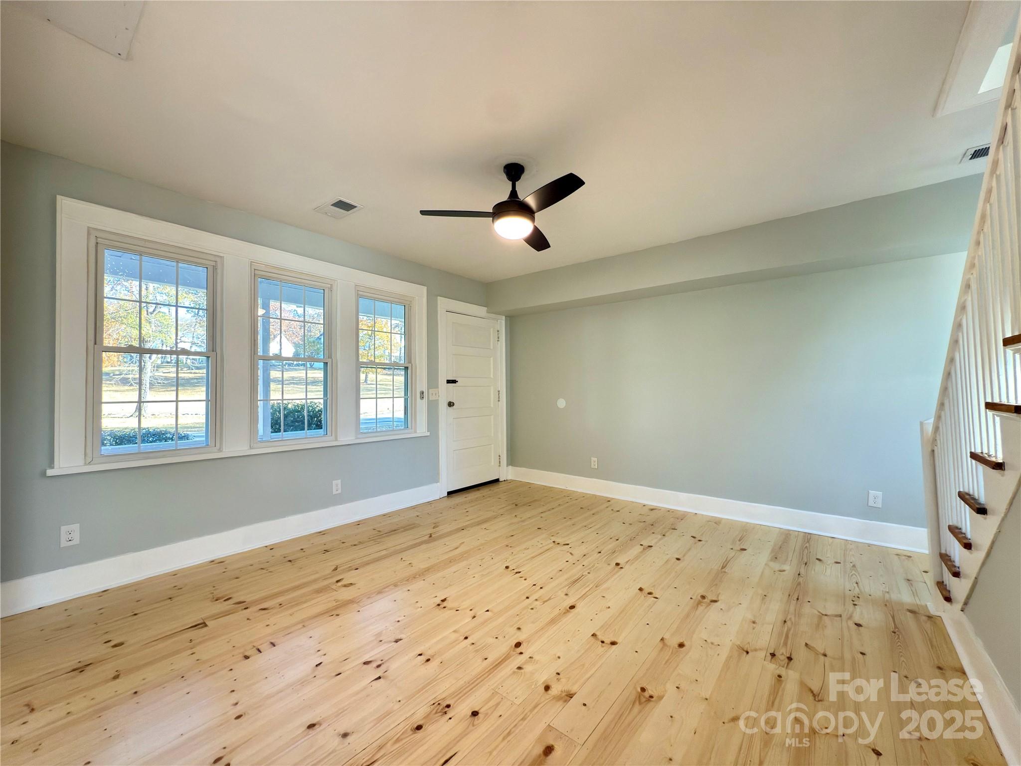 130 Maple Street Badin, NC 28009 - Photo 12 of 24 a view of empty room with wooden floor and fan
