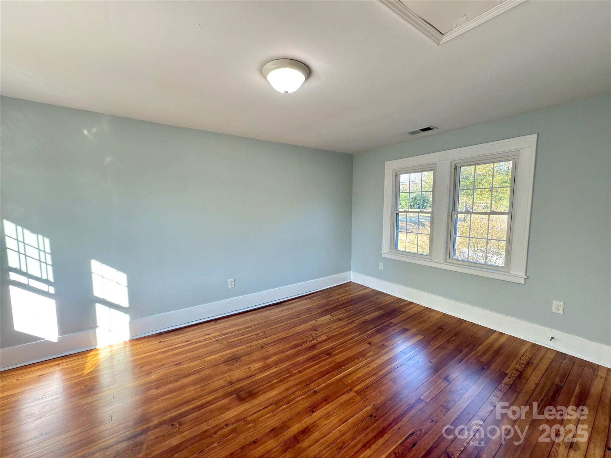 130 Maple Street Badin, NC 28009 - Photo 18 of 24 a view of an empty room with wooden floor and window