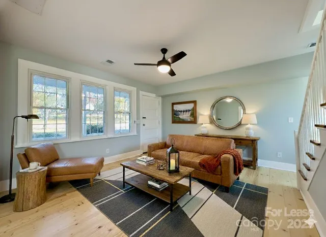 a living room with furniture ceiling fan and a rug