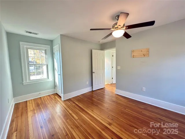 a view of empty room with wooden floor