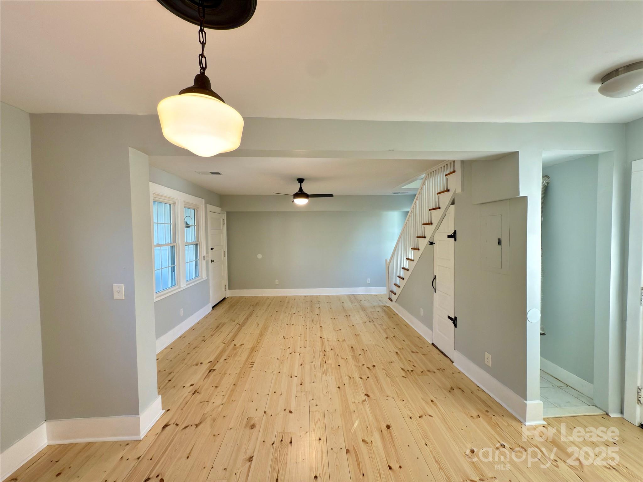 130 Maple Street Badin, NC 28009 - Photo 9 of 24 a view of empty room with wooden floor and fan