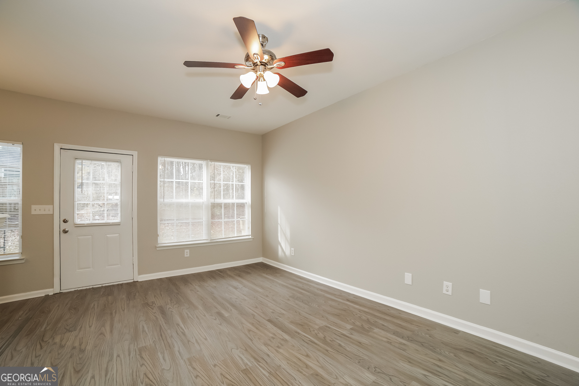 7111 Brookview Way Riverdale, GA 30274 - Photo 4 of 17 wooden floor in an empty room with a window