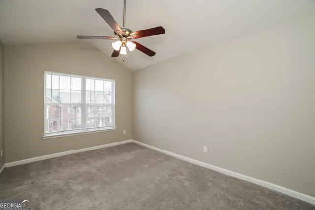 an empty room with a window and a fan
