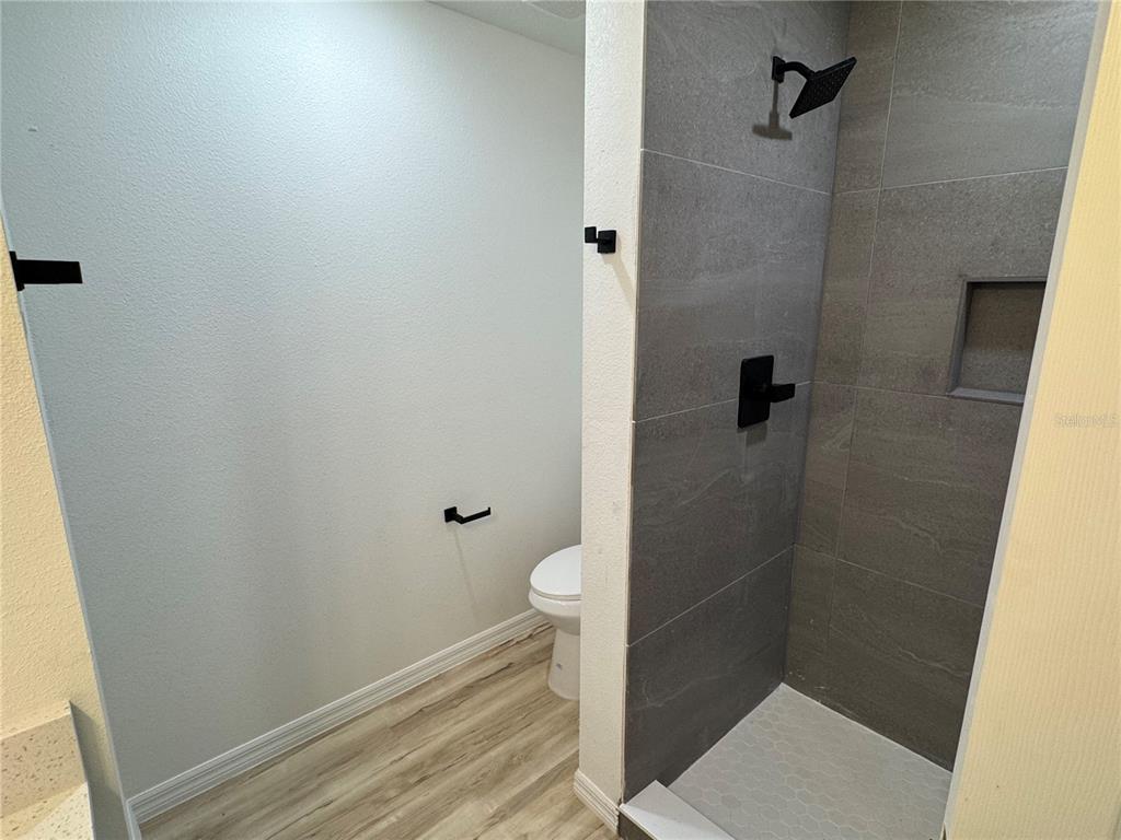 3244 East Deal Street Inverness, FL 34453 - Photo 9 of 17 a bathroom with a granite countertop toilet and a shower