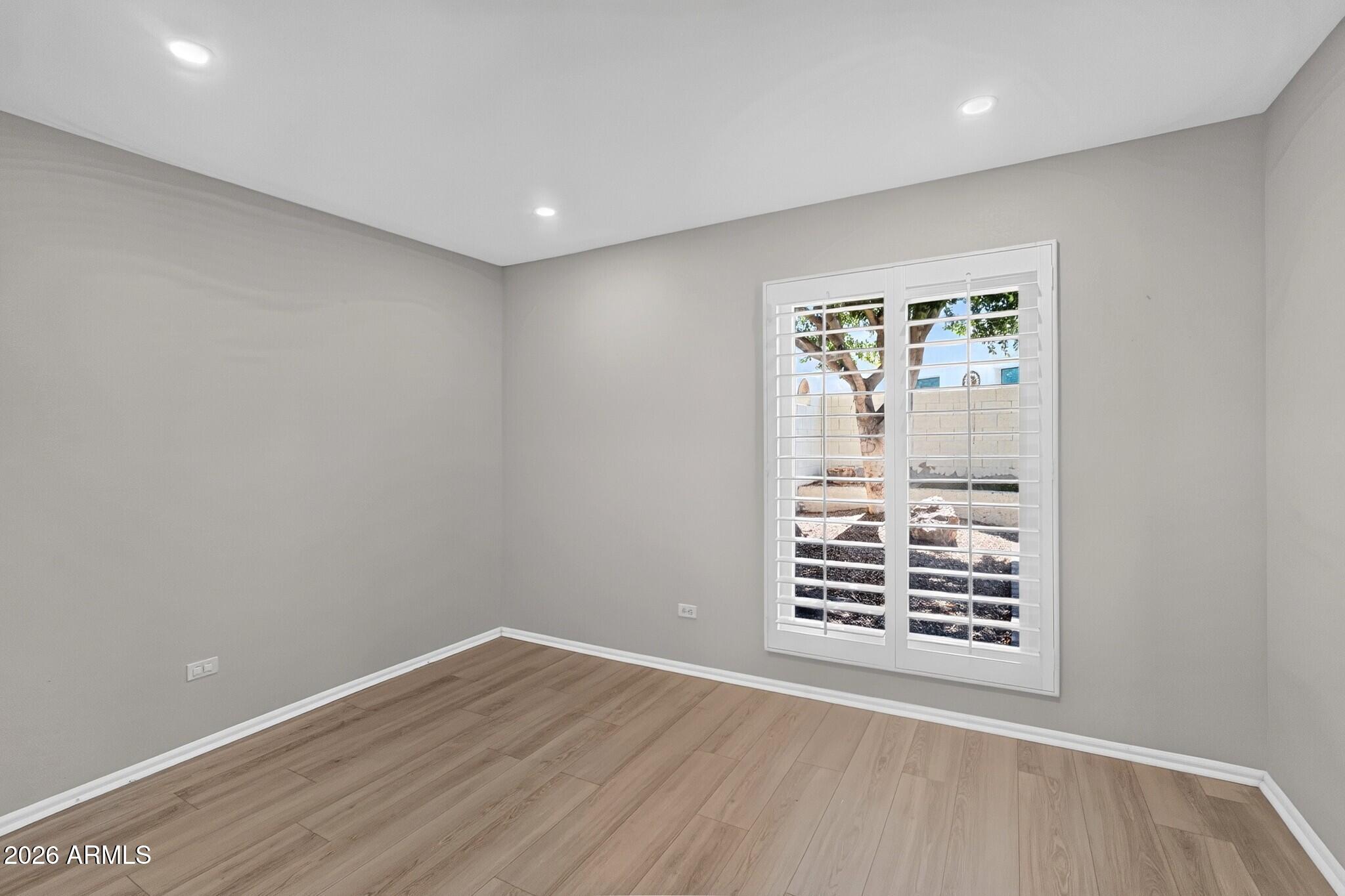 4615 East Monte Way Phoenix, AZ 85044 - Photo 26 of 35 a view of an empty room with wooden floor and a window