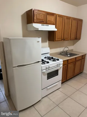 a white refrigerator freezer and a stove sitting inside of a kitchen