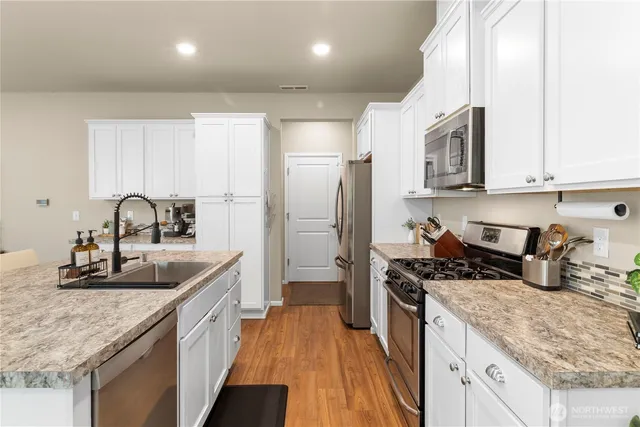 a kitchen with sink a refrigerator and cabinets