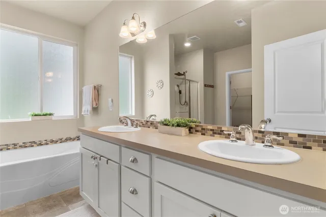 a bathroom with double vanity sinks and a mirror