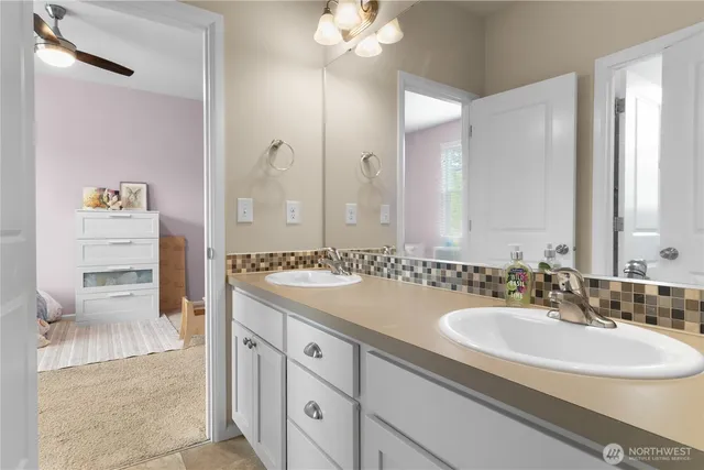 a bathroom with a sink vanity granite tub and a mirror