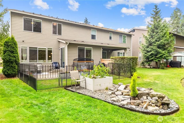 a view of a house with backyard and sitting area