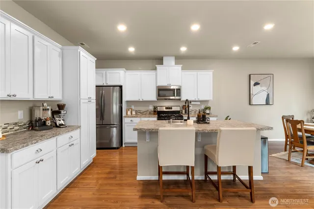 a kitchen with white cabinets and stainless steel appliances