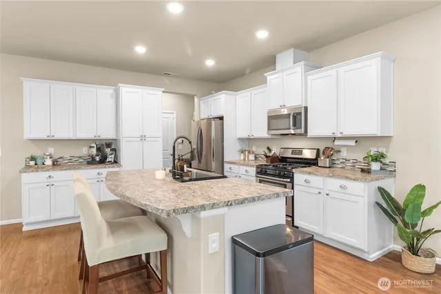 a kitchen with sink a microwave and cabinets