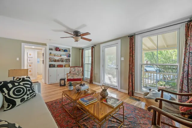 a living room with furniture a flat screen tv and a window