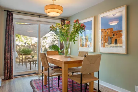 a dining room with furniture potted plants and wooden floor