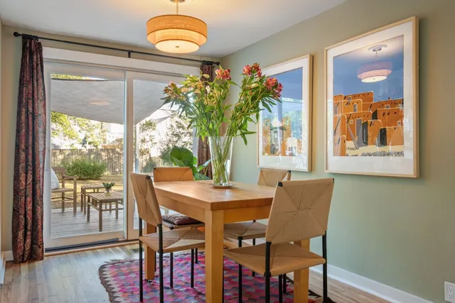 a dining room with furniture potted plants and wooden floor