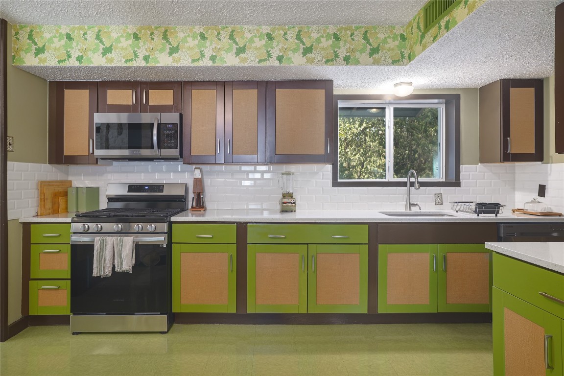 1818 Vance Circle Austin, TX 78701 - Photo 23 of 40 a kitchen with stainless steel appliances granite countertop a stove a sink and a microwave