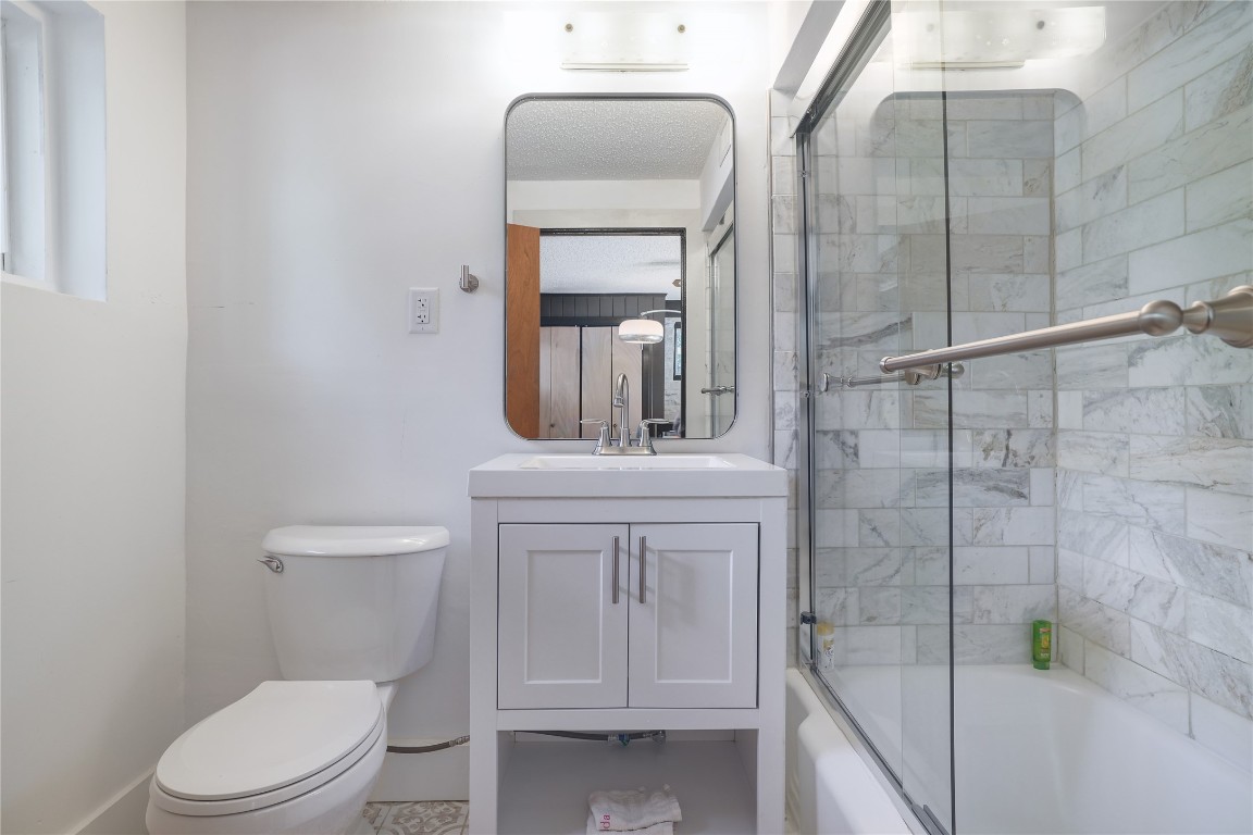 1818 Vance Circle Austin, TX 78701 - Photo 31 of 40 a bathroom with a toilet a sink and mirror